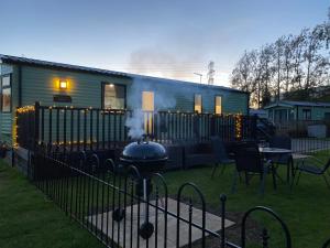 a train car with a grill in a yard at Short escape within Billing Aquadrome in Northampton