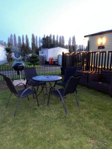 a patio with a table and chairs and a grill at Short escape within Billing Aquadrome in Northampton