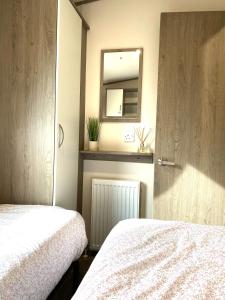 1 Schlafzimmer mit 2 Betten und einem Spiegel in der Unterkunft Short escape within Billing Aquadrome in Northampton