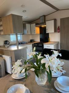 a kitchen with a table with white flowers on it at Short escape within Billing Aquadrome in Northampton
