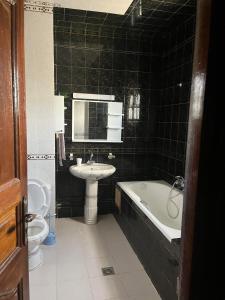łazienka z umywalką, wanną i toaletą w obiekcie Dar louzir à Tazarka w mieście Tazarka
