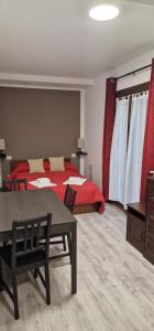 - une chambre avec un lit rouge, une table et un sidx de table dans l'établissement Villa Terzaghi, à Gorla Minore