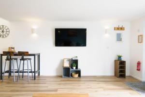 a living room with a table and a white wall at Sennen in Budock Water