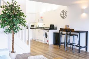 a kitchen with white cabinets and a table and a plant at Sennen in Budock Water