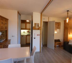 a kitchen and a living room with a white refrigerator at Pied des pistes - Très bel appartement 4 personnes in Valmorel