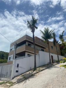 a building with palm trees in front of it at Apartamento Morro do Careca in Natal