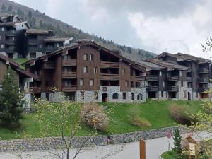 an apartment complex in the mountains with buildings at Pied des pistes - Très bel appartement 4 personnes in Valmorel