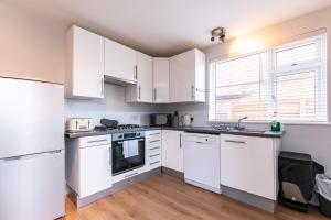 une cuisine avec des appareils électroménagers blancs et une fenêtre dans l'établissement 2 Bedroom House in Chilwell - Perfect for Families and Business, à Beeston