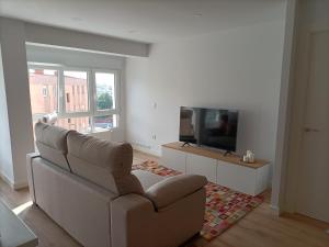サンタンデールにあるPrecioso Apartamento Nuevo Céntrico en Santanderのソファと薄型テレビのあるリビングルーム