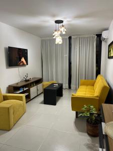 een woonkamer met gele banken en een tv bij Edificio DaLuis in Punta del Este