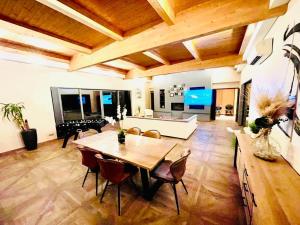 una gran sala de estar con mesa de madera y sillas. en Villa d’architecte avec piscine chauffée en Ligny-en-Cambrésis