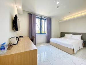 Habitación de hotel con cama y escritorio en The Luxe Hotel Châu Đốc en Chau Doc