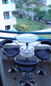a table and four chairs in front of a window at Apartamento Deluxe Isla Margarita - Costa Azul in Porlamar