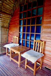 Duas cadeiras e uma mesa de madeira num alpendre em Lanta Marina Resort By Mam&Mod em Ko Lanta