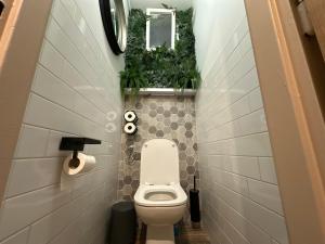 a bathroom with a toilet with plants on the wall at Andel apartment with terrace in Prague