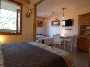 a bedroom with a bed and a table with chairs at Pied des pistes - Très bel appartement 4 personnes in Valmorel