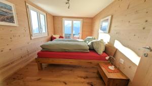 贝特默阿尔卑Imhof Alpine B&B Apartments的木墙和窗户的客房内的一张床位
