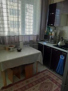 een keuken met een tafel met een witte tafeldoek bij 2-комнатная квартира в центре города in Atıraw