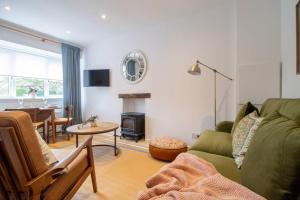 uma sala de estar com um sofá verde e uma mesa em Henry Bell - Cosy 2-bedroom cottage em Helensburgh