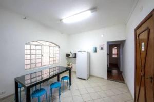 a kitchen with a table and two blue stools at Coliving Brooklin e Chácara Santo Antonio in Sao Paulo
