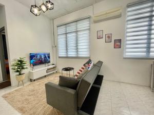 uma sala de estar com um sofá e uma televisão em Home11A#4pax#Netflix#AlmaBukitMertajam em Bukit Mertajam