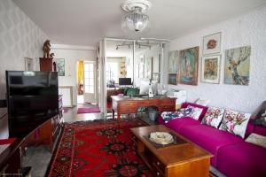 a living room with a purple couch and a table at Viihtyisä ja rauhallinen keskustan tilava kaksio in Turku