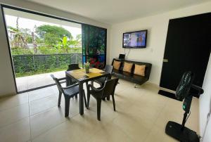 a living room with a table and chairs and a couch at Reserva Quindiana in La Tebaida