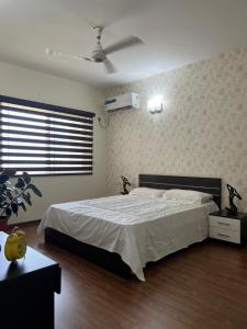 een slaapkamer met een bed en een plafondventilator bij Serene Living at Marine drive at Kochi in Ernakulam