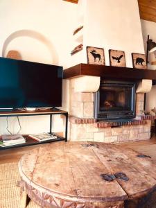 sala de estar con chimenea y mesa de madera en La Cabañita de Llívia, Cerdanya, Puigcerdà en Llivia