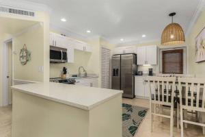 a kitchen with white cabinets and a counter top at Lake Park, 5 O’Clock Somewhere! in Naples