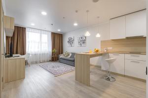 eine Küche und ein Wohnzimmer mit einem Sofa und einem Tisch in der Unterkunft Apart-hotel Ye,s Astana in Taldykolʼ