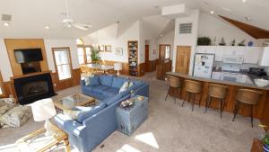 a living room with a blue couch and a kitchen at Oceanside, Hot Tub, Close to beach, Community Pool, CP5, Easy Breezes in Corolla