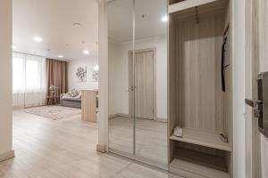 Habitación con una puerta de cristal que da a una sala de estar. en Apart-hotel Ye,s Astana, en Taldykolʼ