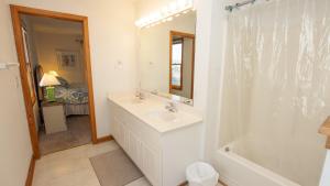 a bathroom with a sink and a tub and a mirror at Oceanside, Hot Tub, Close to beach, Community Pool, CP5, Easy Breezes in Corolla +28 photos