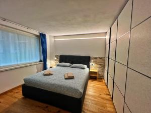 a bedroom with a bed with two books on it at Bonapace Dolomites Apartments in Madonna di Campiglio
