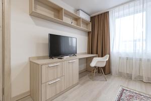 Zimmer mit einem TV auf einem Schreibtisch mit Stuhl in der Unterkunft Apart-hotel Ye,s Astana in Taldykolʼ