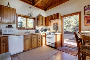 a kitchen with wooden cabinets and white appliances at Romantic Ridgetop Escape with Hot Tub Near Mendocino in Albion