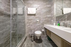 y baño con ducha, aseo y lavamanos. en Apart-hotel Ye,s Astana en Taldykolʼ
