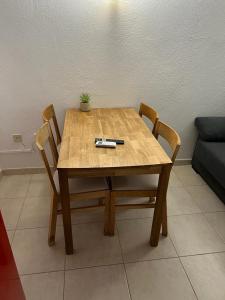 a wooden table with two chairs and a plant on it at apartament la cova in Peralada