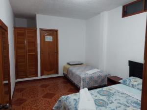 ein Hotelzimmer mit 2 Betten und einer Tür in der Unterkunft Island Suites in Puerto Baquerizo Moreno