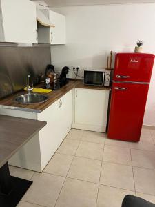 uma cozinha com um frigorífico vermelho e um lavatório em apartament la cova em Peralada