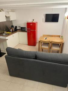 een woonkamer met een bank en een rode koelkast bij apartament la cova in Peralada