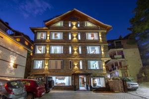 a large wooden building with lights on it at Tripli Hotels Drilbu Manali in Manāli