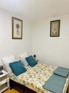 a bedroom with a bed with blue pillows on it at Appartement entier en cœur de ville in Sète