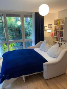 ein Schlafzimmer mit einem Bett, einem Sofa und einem Fenster in der Unterkunft Einliegerwohnung mit Wintergarten (EG) in Kleinmachnow