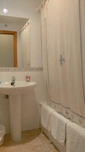 baño con lavabo y cortina de ducha en Hostal Pineda, en Cervera de Pisuerga