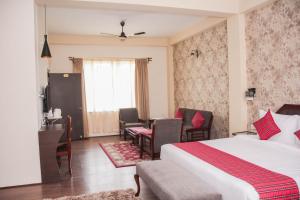 a hotel room with a bed and a desk and chairs at Windermere Inn in Shillong