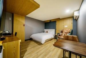 um quarto com uma cama e uma mesa num quarto em Bulgwang 3S Hotel em Seul