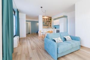 a living room with a blue couch and a kitchen at Cascina 6b in San Maurizio Canavese