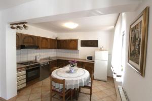 a kitchen with a table with a vase of flowers on it at Apartments Noel in Zambratija